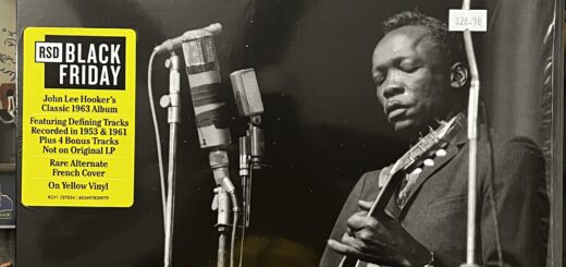 Don't Turn Me From Your Door front cover – the cover features the name "John Lee Hooker" across the top; beneath that in smaller, lower-case italic is the title, "don't turn me from your door." The photograph provides an almost entirely black background. Left of center are three separate types and sizes of microphones on three different stands; another, higher microphone is off to the right. Behind the microphones is John Lee Hooker, a black man in a sharp, dark pin-striped suit, looking down at the guitar he is playing.