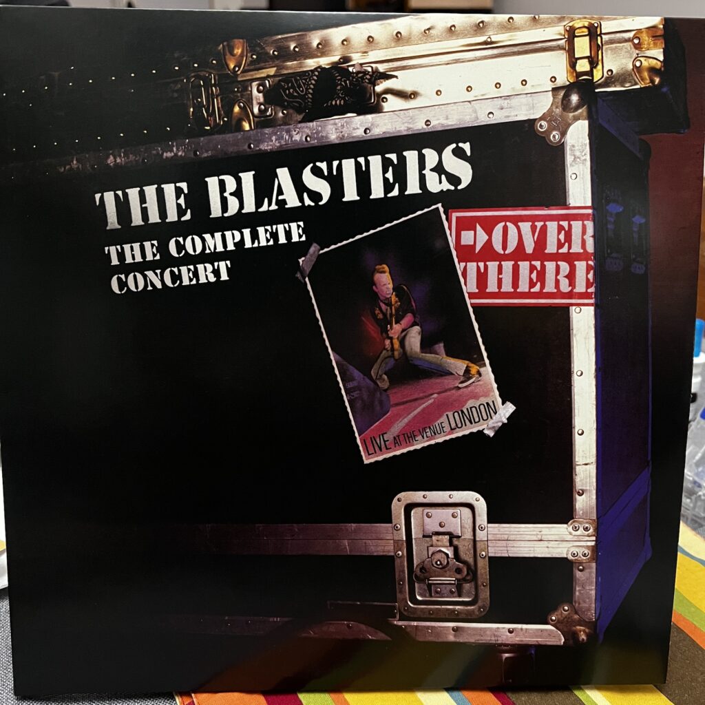 The Blasters Over There Complete Concert album cover. It features an equipment trunk with the titles stenciled on, and a taped-on photograph of Phil Alvin in a deep crouch playing his guitar