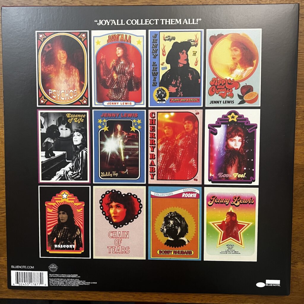 Back cover of Joy'All, which presents each song title as if it were a trading card (four cards across, three rows), with various pictures of Jenny Lewis featured on each card.